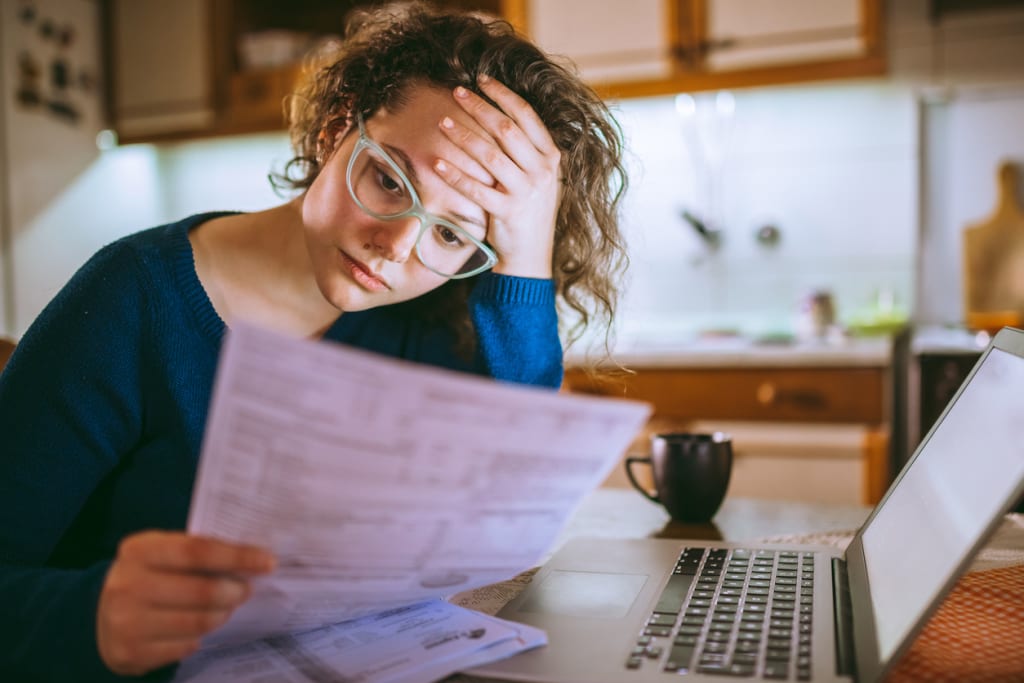 a woman reading insurance documents while sitting at her computer